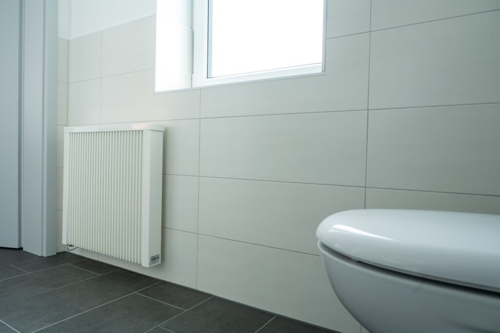 Fahrzeugprüfhalle heizen: Flächenspeicherheizung im Büro, Dunkelstrahler in der Halle Flächenspeicherheizung in der Kundentoilette einer Prüfhalle