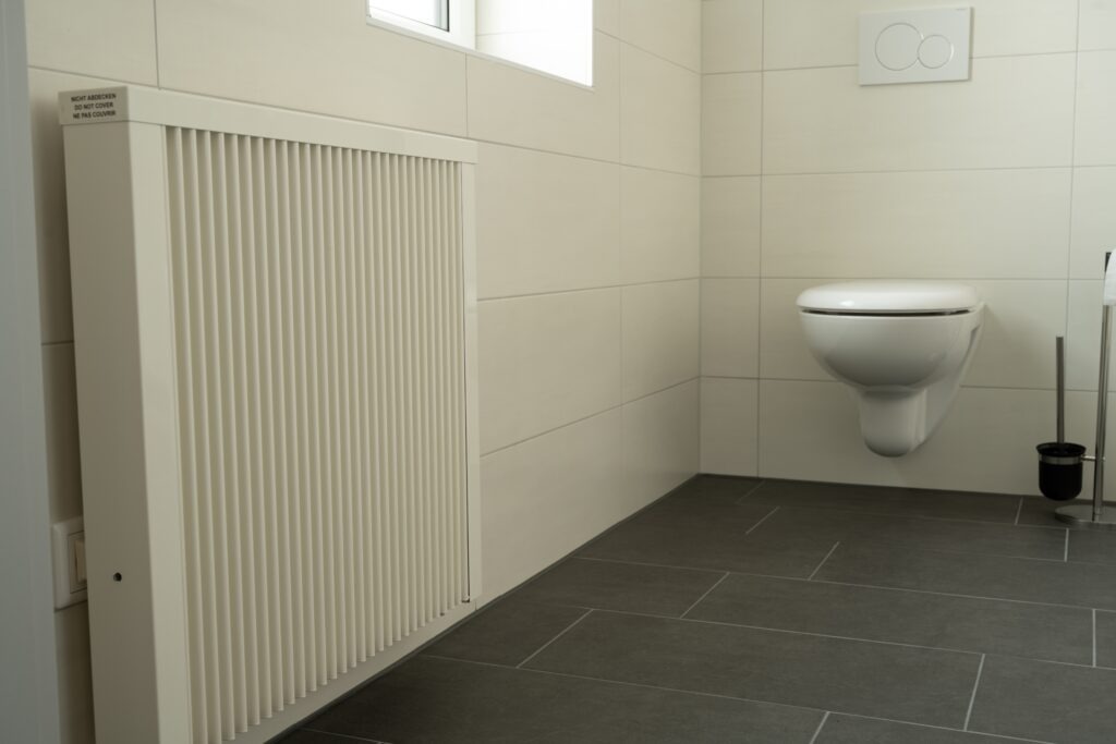 Fahrzeugprüfhalle heizen: Flächenspeicherheizung im Büro, Dunkelstrahler in der Halle Flächenspeicherheizung im Sanitärraum eines Prüfbetriebs
